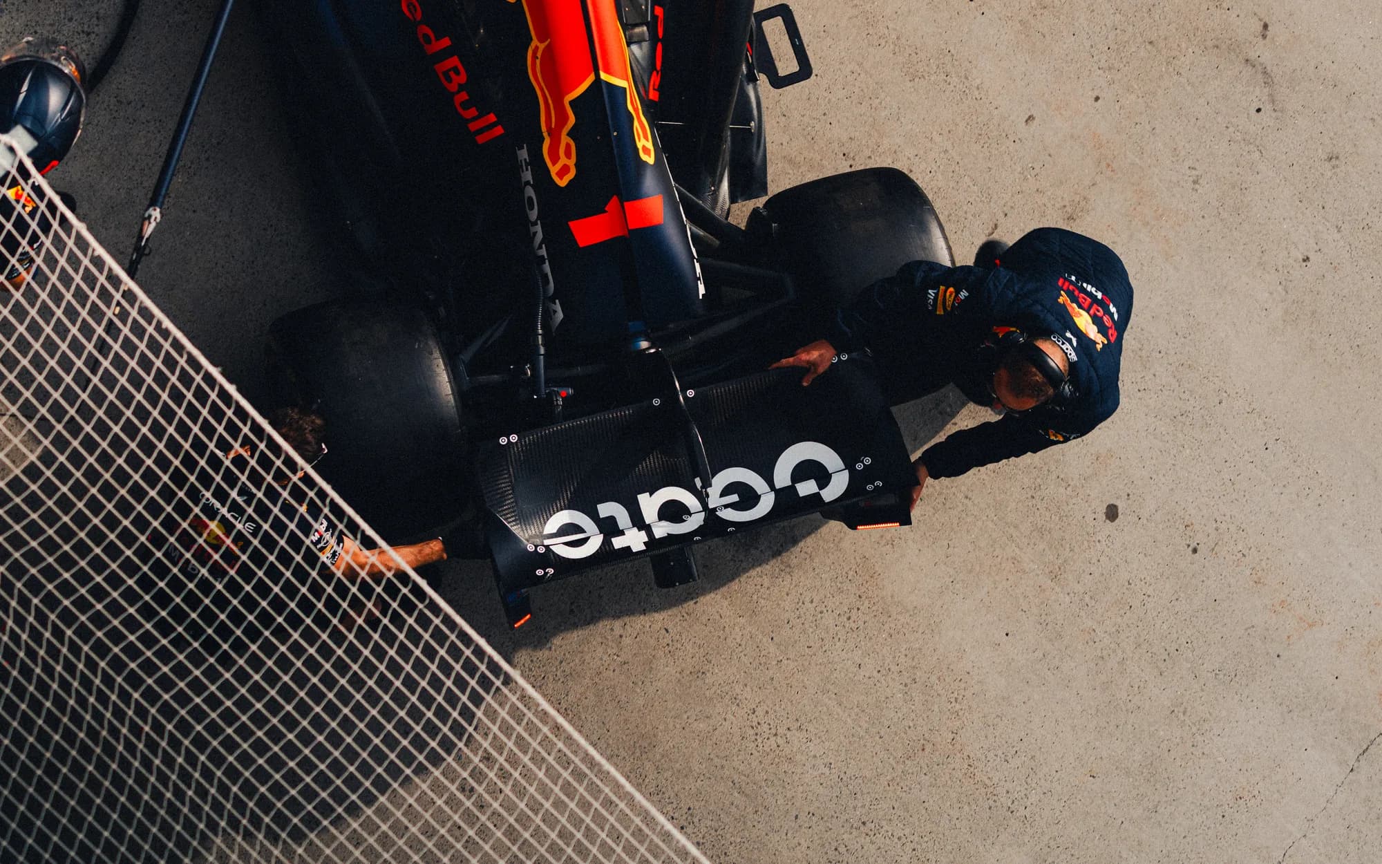 Overhead frame of a mechanic steadying the Red Bull in the pit lane