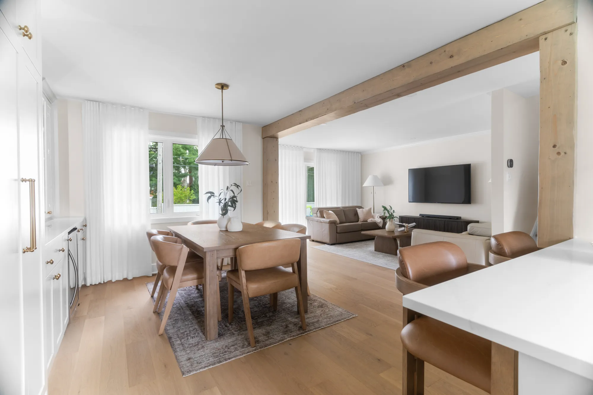 Open living and dining space framed by structural wood beams